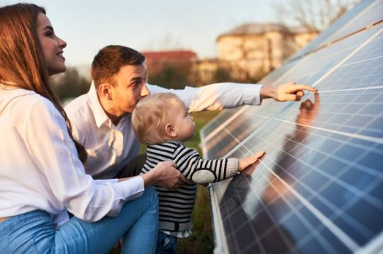 Família conhecendo de perto um painel solar da Leandro Energia Solar